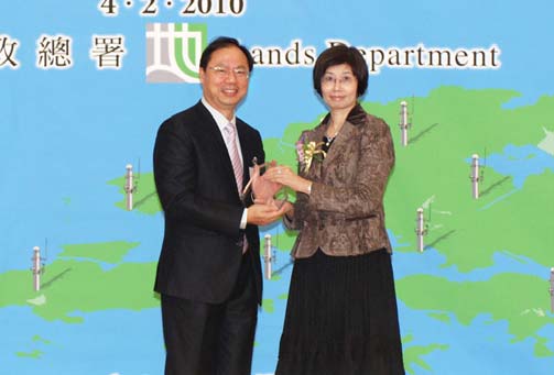 Ms Annie TAM, Director of Lands presents a souvenir to Mr. Simon KWOK, CLS/U as one of the workshop speakers.